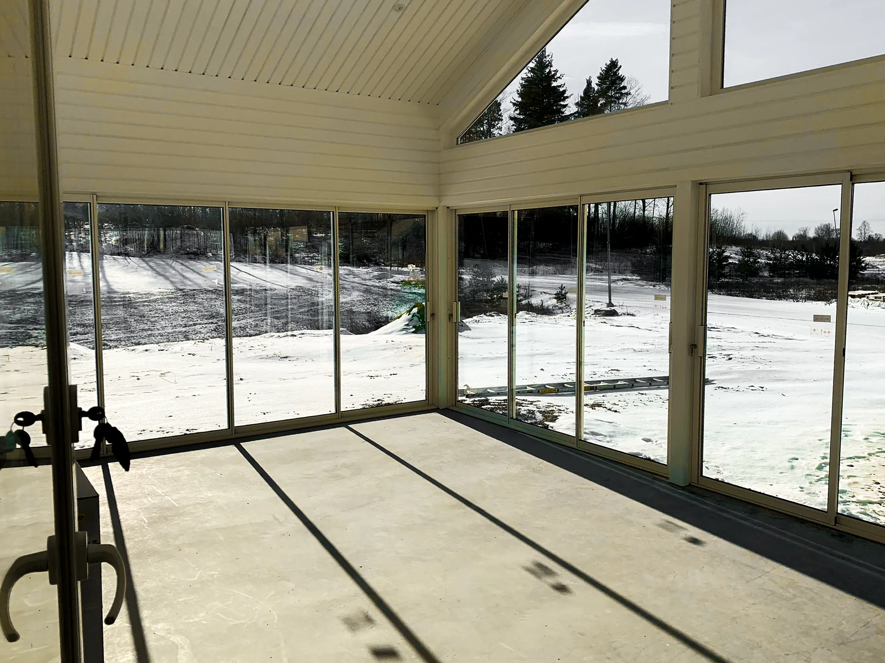 Inglasat rum med glaspartier från golv till tak och snö utanför