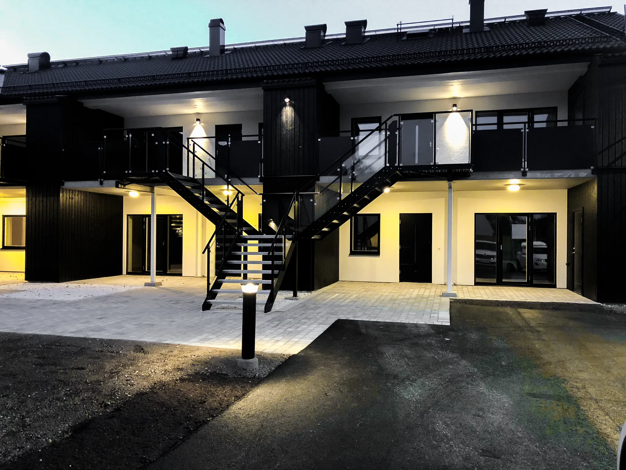Nybyggda radhus i kvällsljus med tända fönster