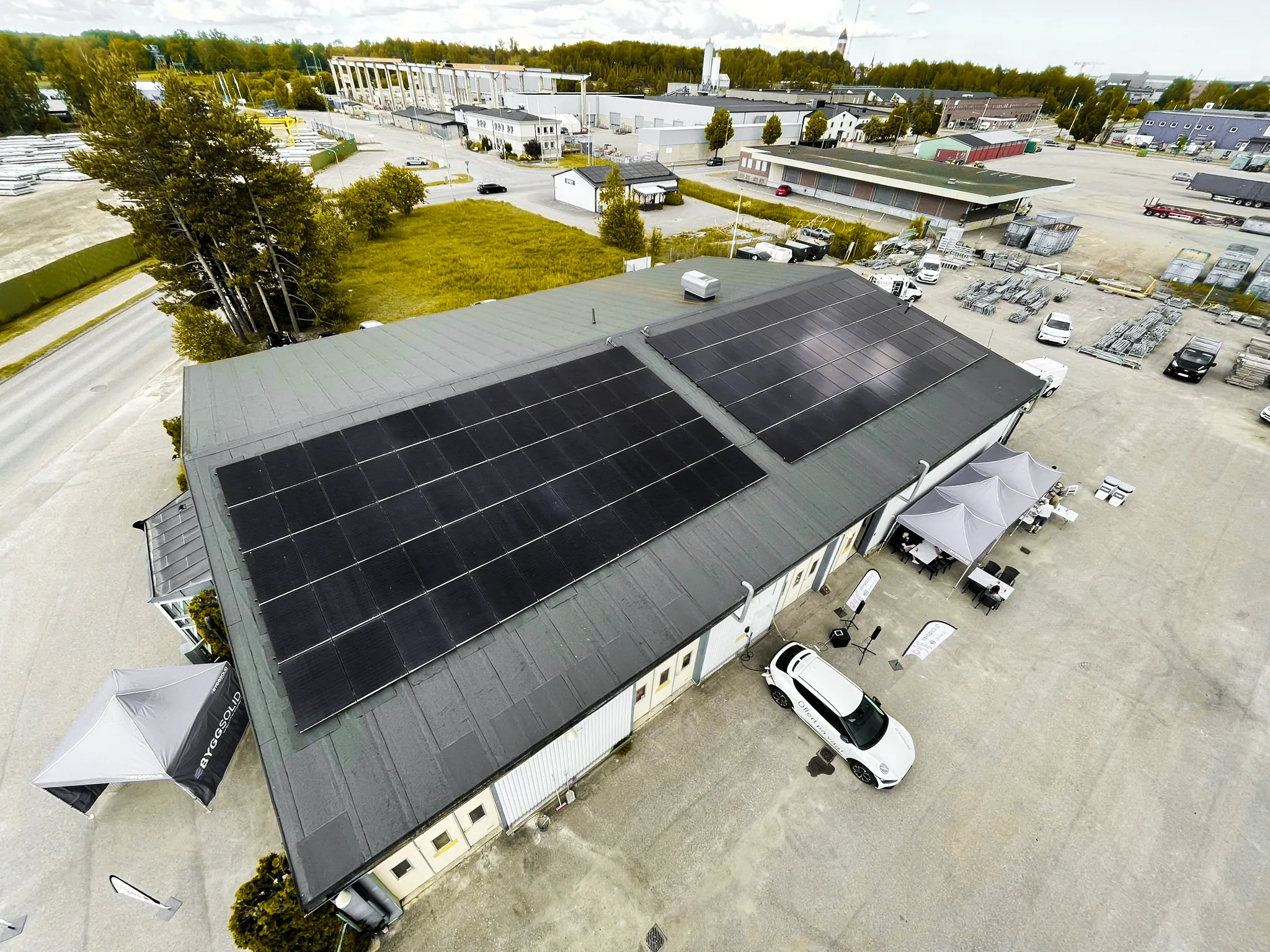 Byggsolids egen fastighet med solceller på hela taket och servicebilar på gården, sedd från luften
